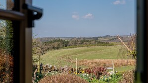 A view of a rural landscape with a stone wall and a wire fence in the foreground, leading to a green field and trees in the distance. - Inglewood, Kirkoswald - sleeps 4 guests  in 2 bedrooms (Kirkoswald)