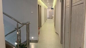 A modern hallway with a glass railing, a light-colored carpet, and wooden doors. - Liru Tujia Hostel (Beijing)