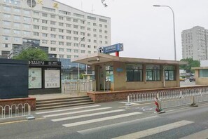 A building with a large entrance, a signboard, and a pedestrian crossing. - Liru Tujia Hostel (Beijing)