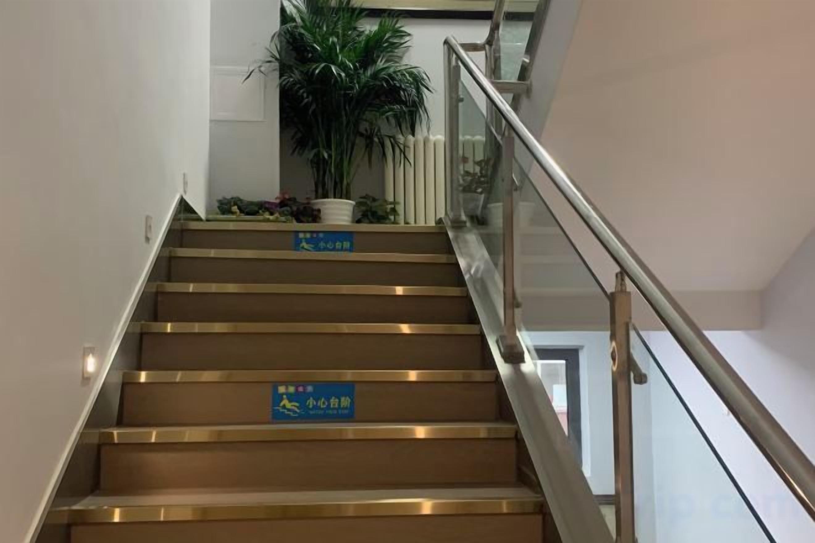 A staircase with handrails and signs indicating a non-smoking area.