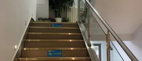 A staircase with handrails and signs indicating a non-smoking area.