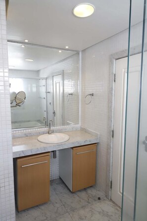 A bathroom with a white sink, two mirrors, and a glass shower enclosure. - Luxurious Penthouse in Belém (Umarizal Belém)