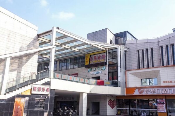 A multi-level commercial building with a glass facade, a staircase, and various storefronts. - Yixing Hotel (Shanghai Zhujiajiao Ancient Town Scenic Area Branch) (Shanghai)