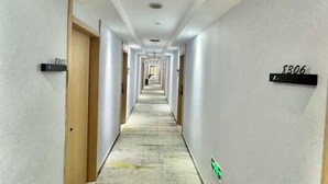 A long, narrow hotel corridor with doors labeled 8303 and 8306. - Yixing Hotel (Shanghai Zhujiajiao Ancient Town Scenic Area Branch) (Shanghai)