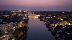 A riverside town with a bridge, buildings, and a calm water body. - Yixing Hotel (Shanghai Zhujiajiao Ancient Town Scenic Area Branch) (Shanghai)
