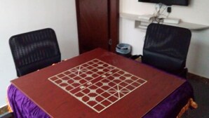 A room with a square table covered with a red cloth and a geometric pattern, flanked by two black chairs. - Yixing Hotel (Shanghai Zhujiajiao Ancient Town Scenic Area Branch) (Shanghai)