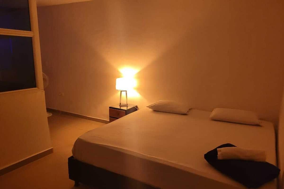 Ein Hotelzimmer mit einem Bett, einem Nachttisch und einer Lampe.