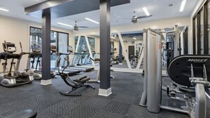 A gym with treadmills, elliptical machines, and weightlifting equipment. - Mid-Century Charm | Midtown (Nashville)