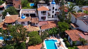 A resort with multiple buildings, a swimming pool, and lush greenery. - Aventura Pacifico Boutique Suites Villas (Bucerías)