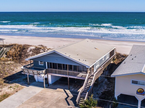 Overlooking the ocean, this property features a flat roof, balcony, and covered parking area.