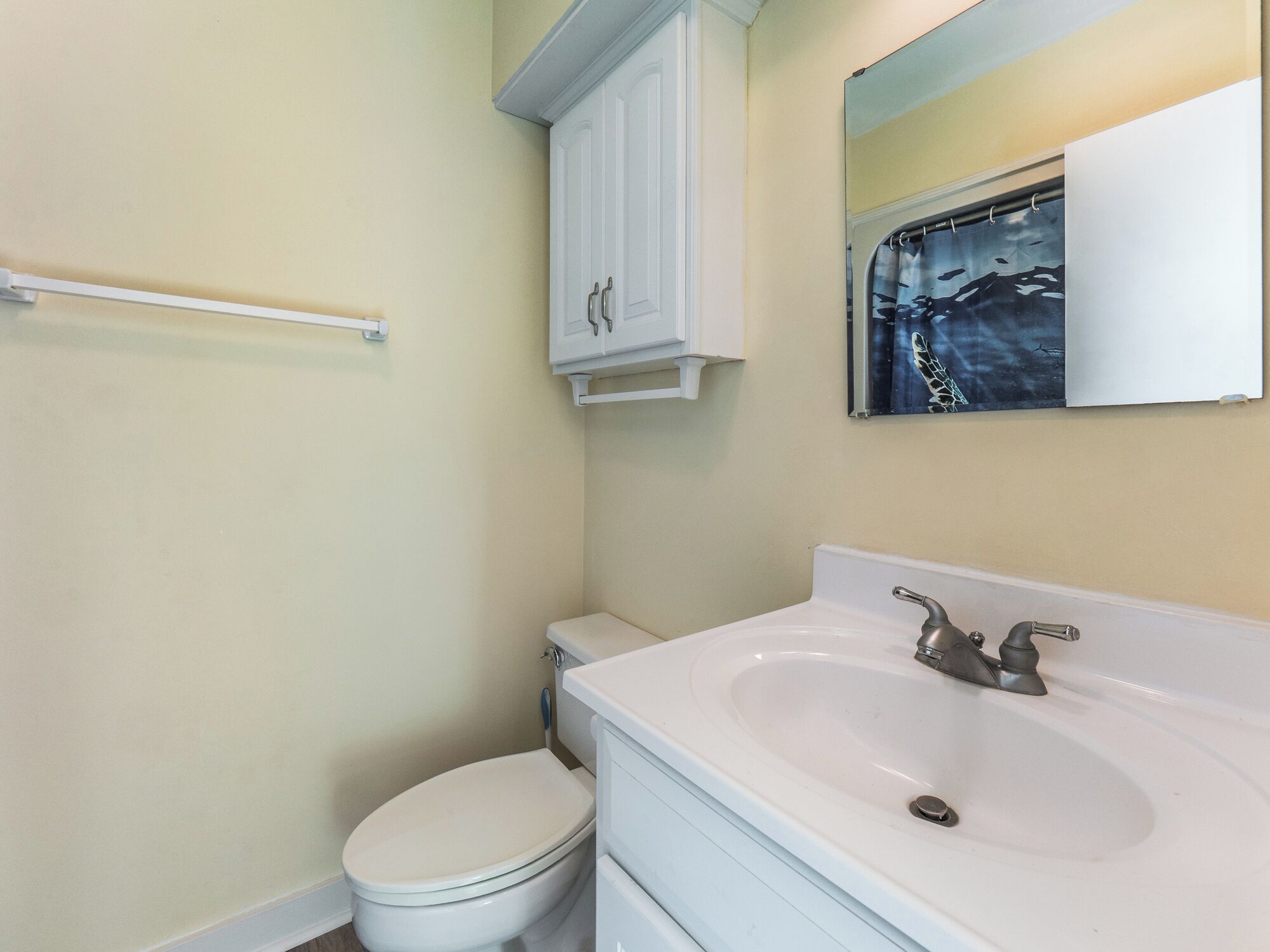 Un baño con inodoro, lavabo y espejo.