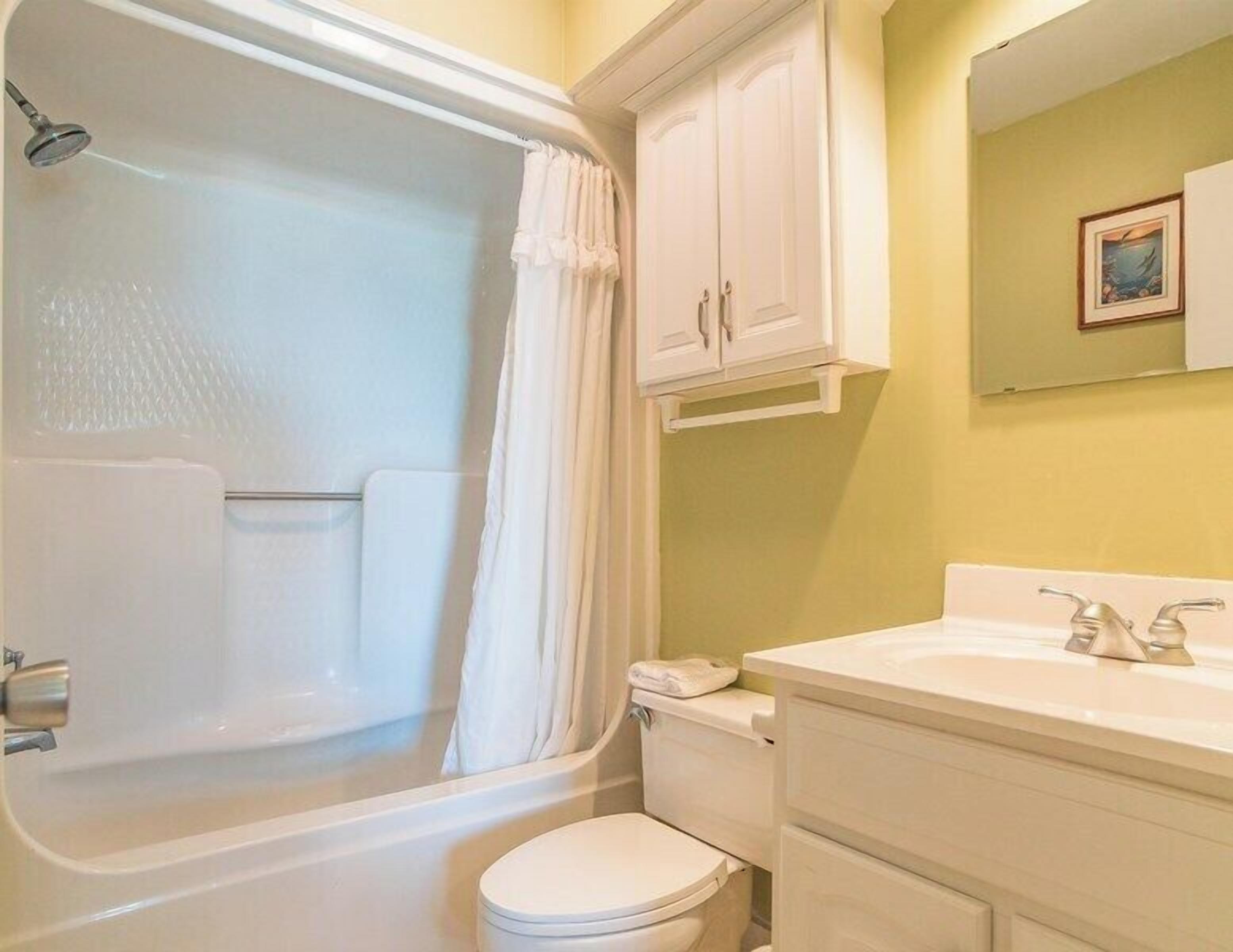 A bathroom with a bathtub, toilet, and sink.
