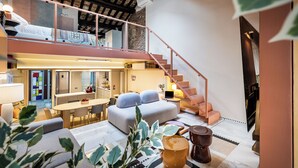 A modern interior with a loft bedroom, a dining area, and a staircase. - Altiora - Luxury loft in Rome (Roma)