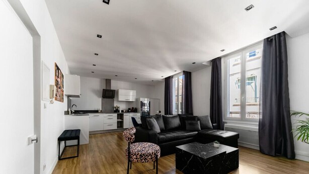 A modern living room with a black sofa, a leopard print chair, and a marble coffee table. - Le Gilbert 1 - 10 impasse Gilbert - Vichy (Vichy)