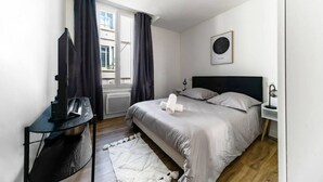 A modern bedroom with a bed, bedside tables, a desk, and a window with curtains. - Le Gilbert 1 - 10 impasse Gilbert - Vichy (Vichy)