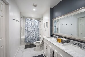 Une salle de bain moderne équipée d’une douche, de toilettes et d’un lavabo.