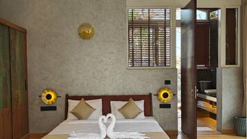 A bedroom with a large bed, a ceiling fan, a window with blinds, and a wooden floor.