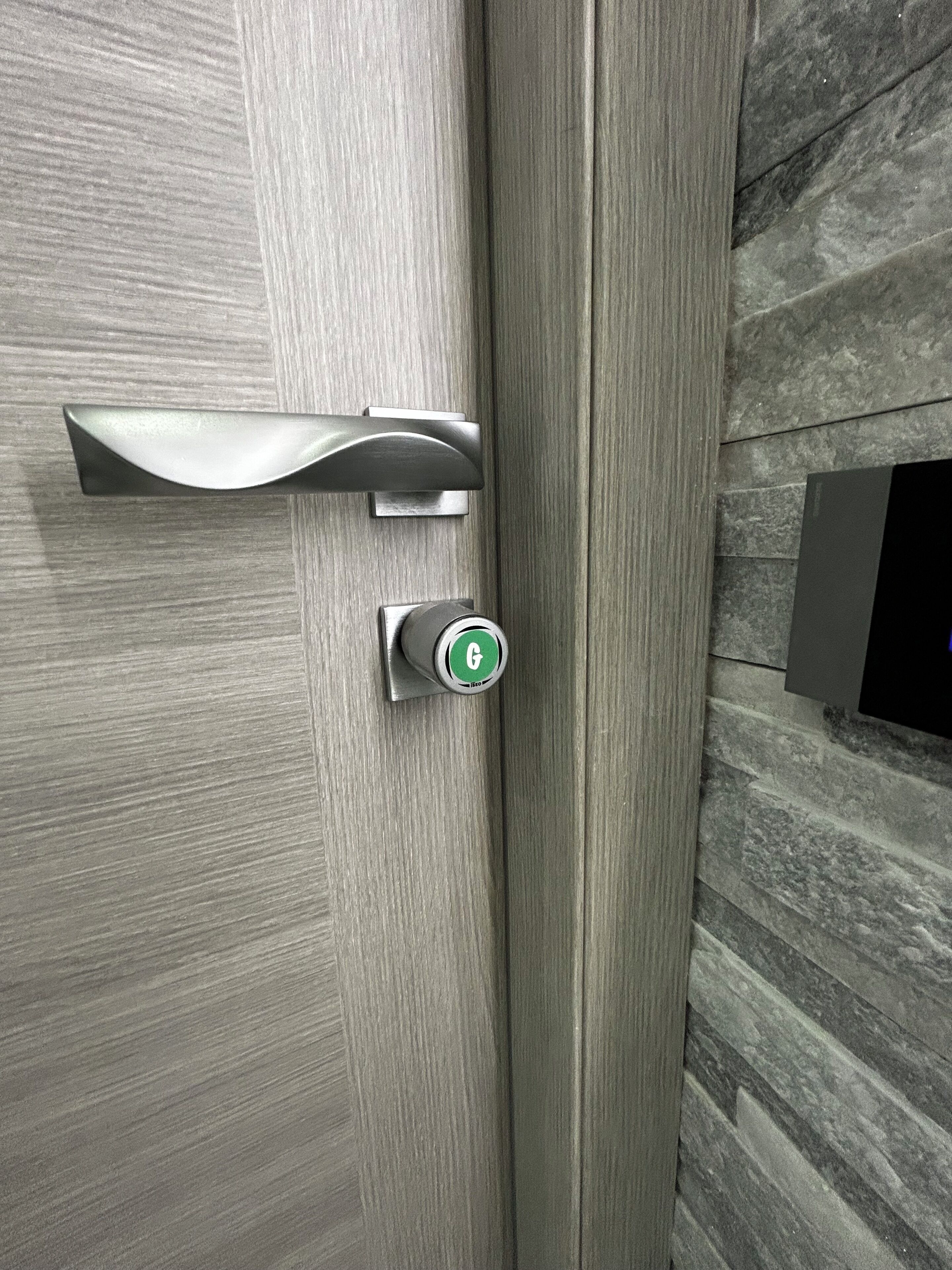 A modern door with a sleek handle and a keycard lock.