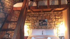 A cozy room with a stone wall, a wooden ladder, a bed with white linens, and two bedside lamps. - Το Erymanthos country home είναι μια πέτρινη μεζονέτα για στιγμές χαλάρωσης (Skepasto)