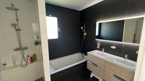 Chuveiro, secador de cabelo, toalhas de banho, papel higiênico