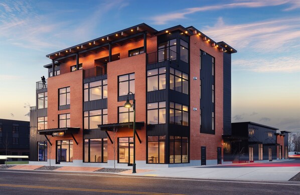 A modern multi-story building with large windows and a flat roof.
