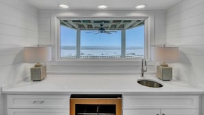 Ein modernes Badezimmer mit großem Fenster, Deckenventilator und zwei Wandleuchten.
