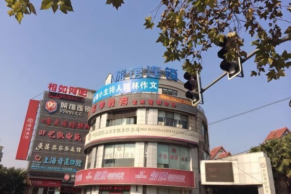 A multi-story building with various signs and advertisements. - 99 Inn (Shanghai Dahua Xingzhi Road Subway Station) (Shanghai)