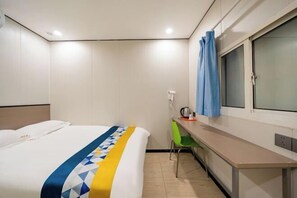 A hotel room with a bed, a desk, a chair, a window with curtains, and a wall-mounted kettle. - 99 Inn (Shanghai Dahua Xingzhi Road Subway Station) (Shanghai)