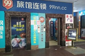 A 99 Inn hotel entrance with a signboard, a door, and a small display board. - 99 Inn (Shanghai Dahua Xingzhi Road Subway Station) (Shanghai)