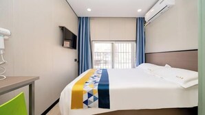 A hotel room with a bed, a desk, a chair, an air conditioning unit, and a window with curtains. - 99 Inn (Shanghai Dahua Xingzhi Road Subway Station) (Shanghai)