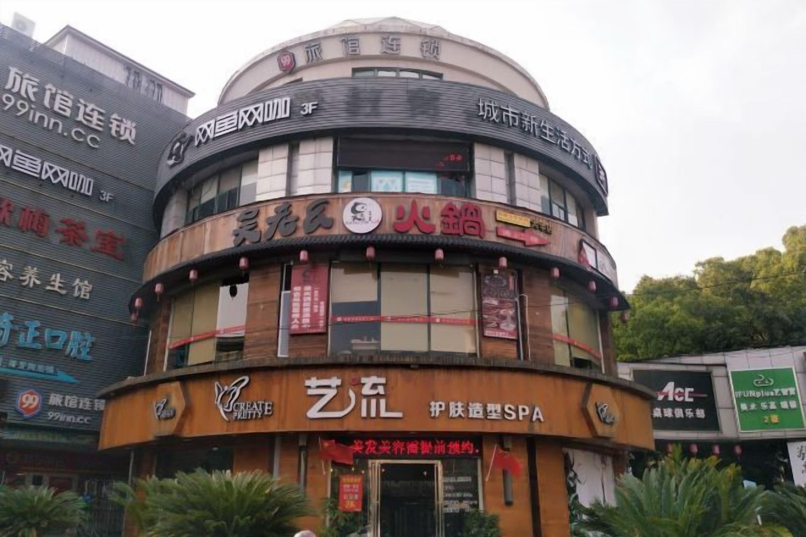 A multi-story building with a curved facade, featuring various commercial establishments including a spa and a restaurant.