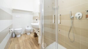 Ein modernes Badezimmer mit einer Duschkabine aus Glas, einer weißen Toilette und einem Bidet.