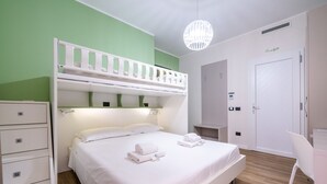 Une chambre avec un lit superposé, un bureau et une chaise.