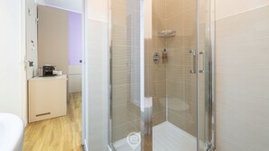 Ein modernes Badezimmer mit Duschkabine, kleinem Waschbecken und Toilette.