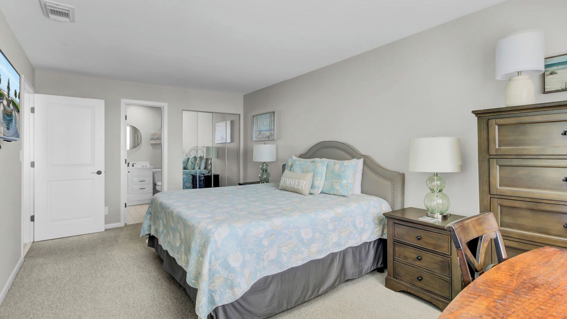 A bedroom with a bed, a dresser, a nightstand, and a chair.