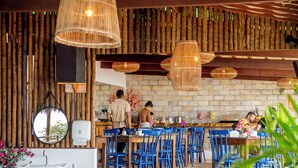 Un restaurante con una decoración rústica, que presenta vigas de madera, paredes de piedra y sillas azules.