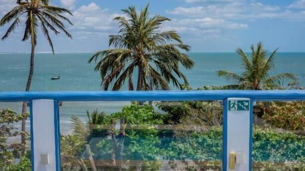 Una piscina con vista al océano y palmeras.