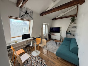 Uma sala de estar moderna com uma mesa de vidro, um sofá azul e uma televisão.