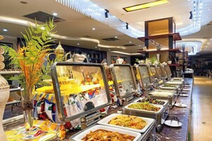 Un bufé con distintas estaciones de comida y elementos decorativos.