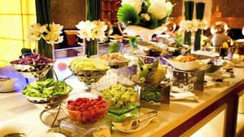 Una mesa de buffet con diferentes alimentos y un arreglo floral.