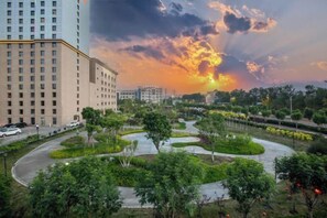 A modern building complex with a landscaped garden area featuring winding paths and greenery. - Kashi Laining Hotel (Kashgar City)