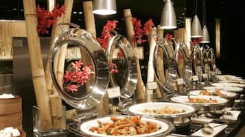A buffet setup with multiple serving stations, each with a large metal bowl and a label.