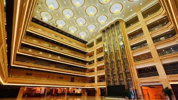 A multi-level atrium with a grand staircase, multiple floors, and a reflective floor.