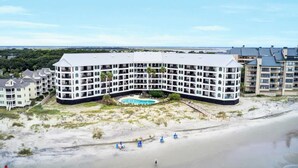 Un hôtel à plusieurs étages doté d’une piscine et d’un accès à la plage.