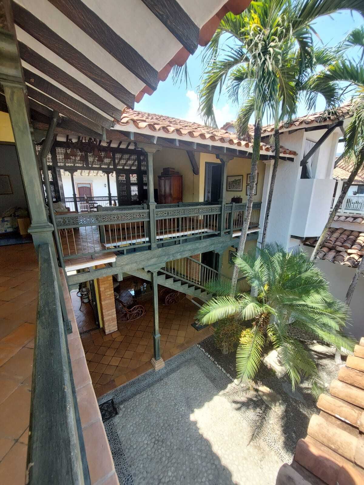 A multi-level outdoor patio with a tiled floor, a wooden staircase, and a railing.