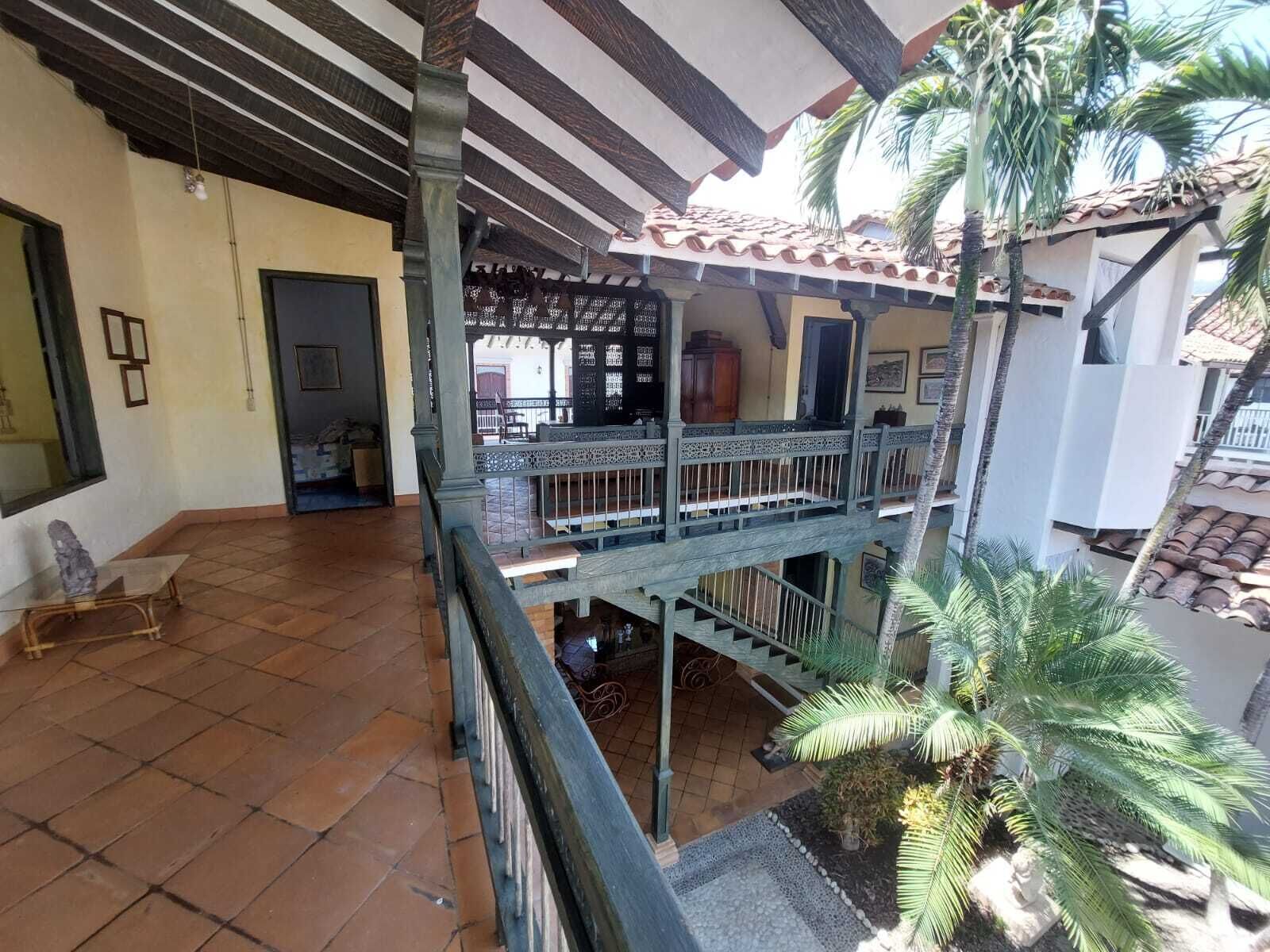 A multi-level building with a balcony, tiled flooring, and a staircase.