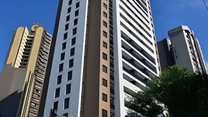 A tall, modern building with a white facade and horizontal lines. - Apto 2 Quartos com Churrasqueira no Sky Batel · Piscina Aquecida e Sauna (Curitiba)