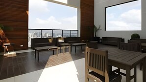 A spacious outdoor seating area with wooden furniture and a city view. - Apto 2 Quartos com Churrasqueira no Sky Batel · Piscina Aquecida e Sauna (Curitiba)