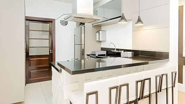 A modern kitchen with a large island, stainless steel appliances, and pendant lighting. - Apartamento 3 Quartos 116m² no Batel Curitiba (Curitiba)