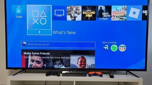 Een televisie waarop een game-interface wordt weergegeven, met een boekenkast eronder.